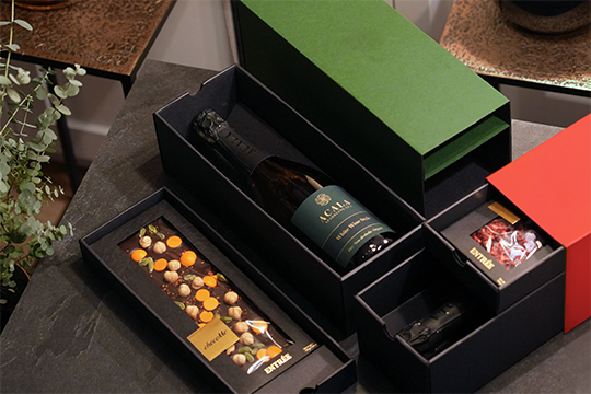 Gift boxes with drawers containing a bottle and chocolate